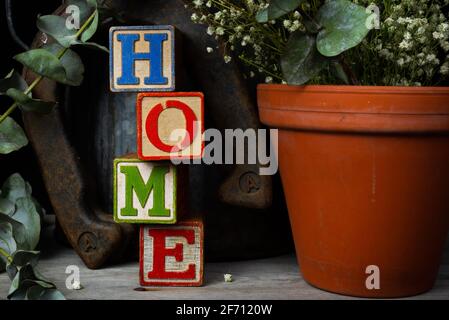 'Home' scritto in blocchi di legno d'epoca con sfondo rustico. Foto Stock