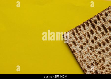 Un primo piano di un pane matzah per la Pasqua ebraica, su sfondo giallo Foto Stock