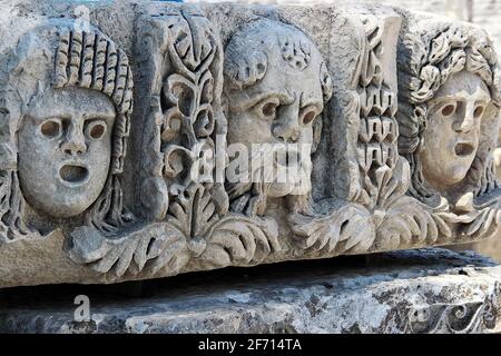 Maschere teatrali adornano i blocchi di pietra di fronte alla facciata del teatro. L'antico teatro greco-romano di Myra (Demre - Turchia). Foto Stock