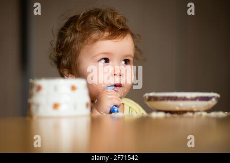 Bambino che mangia, concetto di nutrizione. Un bambino che mangia cibo da una ciotola. Foto Stock