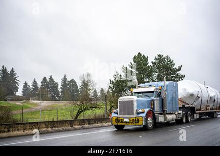 Semirimorchio Blue Classic Big RIG con segnale di carico sovradimensionato sul paraurti per il trasporto di carichi coperti di grandi dimensioni durante il discesa semirimorchio in esecuzione su hi Foto Stock