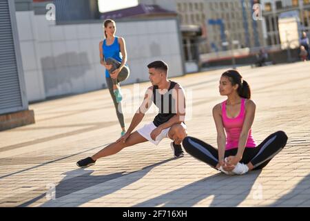 Tre atleti che si riscaldano in città Foto Stock