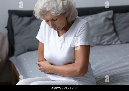 Donna anziana sconvolto anni '60 sentendo forte dolore allo stomaco Foto Stock