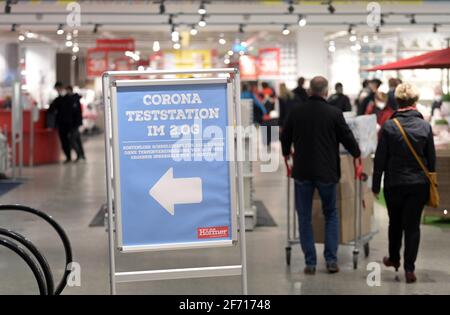 03 aprile 2021, Brandeburgo, Schönefeld: Un cartello al primo piano del negozio di mobili Möbel-Höffner indica la strada per la stazione di prova di Corona. Nel negozio di mobili, i clienti possono avere essi stessi testato per il virus Corona gratuitamente prima di fare acquisti come parte dei cosiddetti test Citizen. Foto: Soeren Stache/dpa-Zentralbild/ZB Foto Stock