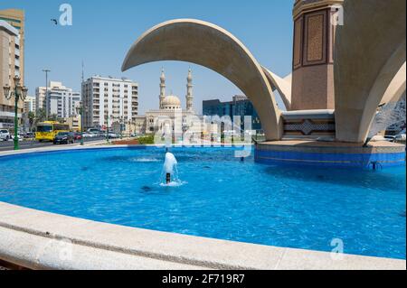 Sharjah, Emirati Arabi Uniti - 24 Marzo 2021:la moschea di Zahra e la fontana della Torre dell'Orologio di Sharjah emirano il centro nel basso angolo vi degli Emirati Arabi Uniti Foto Stock