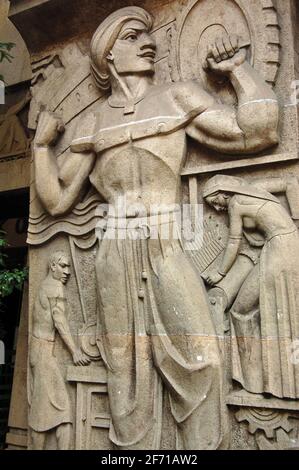 Una scultura in pietra art deco raffigurante l'industria sulla strada che guarda alle pareti di un edificio nel centro di Mumbai (ex Bombay). La scultura è superiore a 70 Foto Stock