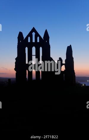 Whitby Abbey silhouette al tramonto a Whitby, North Yorkshire, UK Foto Stock