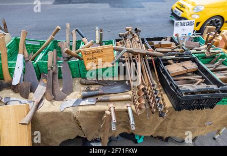 Esposizione di attrezzi in vendita sul pavimento fuori di un negozio al bivio di East e West Street, Bridport, una città di mercato a Dorset, a sud-ovest di Englan Foto Stock