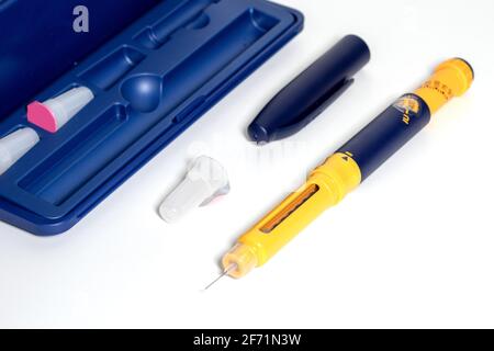 Penna per insulina con goccia di insulina sulla punta dell'ago isolata su fondo bianco. I dispositivi medici sono usati per auto-iniezione per il trattamento della malattia di diabete. WO Foto Stock