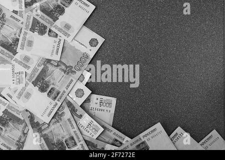 Banconote in contanti russe di cinquemila rubli, sparse su sfondo grigio, c'è un posto per l'iscrizione e il testo. Layout, layout. Foto Stock
