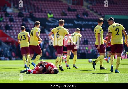 Jan Bednarek di Southampton è ferito mentre i giocatori di Burnley corrono da lui durante la partita della Premier League a St Mary's, Southampton. Data immagine: Domenica 4 aprile 2021. Foto Stock