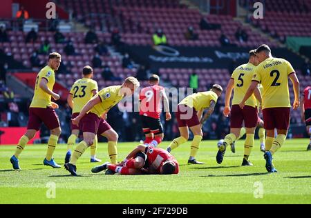 Jan Bednarek di Southampton è ferito mentre i giocatori di Burnley corrono da lui durante la partita della Premier League a St Mary's, Southampton. Data immagine: Domenica 4 aprile 2021. Foto Stock