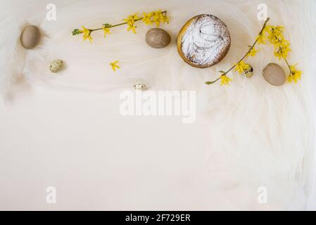 Torta di Pasqua, uova, rami di forsizia su sfondo beige. Spazio per la copia, giacitura piatta. Concetto di Pasqua Foto Stock