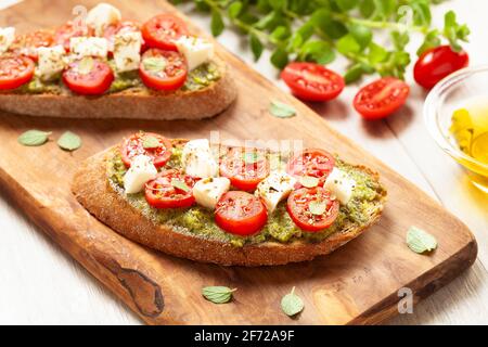 Antipasti di bruschette con pesto e mozzarella di ciliegia tomatos Foto Stock