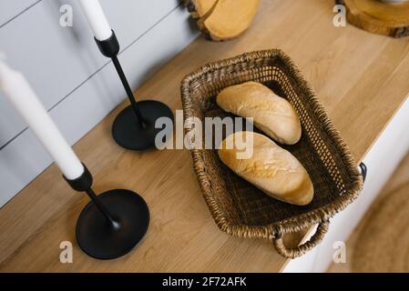 Due panini francesi in un cestino di vimini sul Piano cucina in stile scandinavo Foto Stock