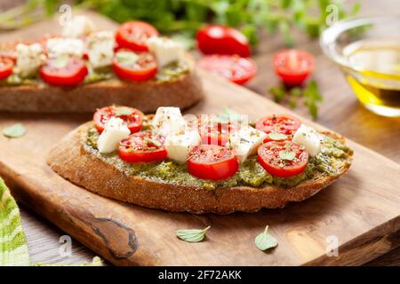 Antipasti di bruschette con pesto e mozzarella di ciliegia tomatos Foto Stock