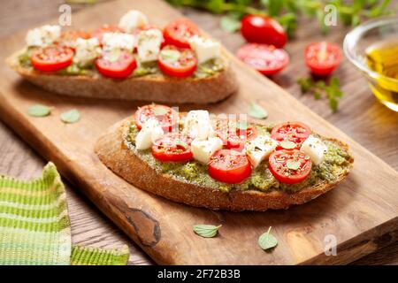 Antipasti di bruschette con pesto e mozzarella di ciliegia tomatos Foto Stock