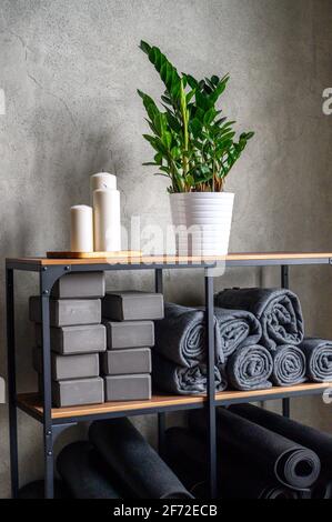 l'interno della sala è uno studio per lo yoga sportivo o lo stretching. tavolo con accessori per le lezioni - cubi di sostegno grigio, tappetini in gomma e plai Foto Stock