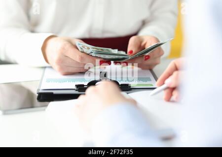 Le mani femminili stanno contando i contanti al tavolo di lavoro Foto Stock