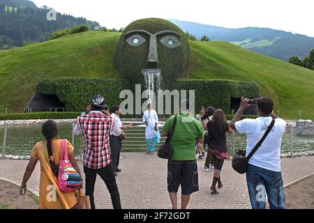 Wattens, Tirolo/Austria: Turisti che guardano al Gigante, una fontana creata dall'artista austriaco André Heller, situata all'ingresso di Foto Stock