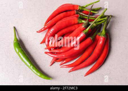 Scivola di peperoncino rosso con un verde su uno sfondo chiaro. Vista dall'alto. Foto Stock