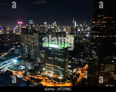 Spettacolare skyline notturno di una grande città moderna di notte. Giacarta, Indonesia. Vista aerea su autostrade e grattacieli con nube di rumore. Giacarta, in Foto Stock