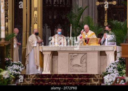 Il Cardinale Timothy Dolan, Arcivescovo di New York, celebra l'Eucaristia durante la Veglia pasquale in una Messa socialmente distanziata nella Cattedrale di San Patrizio a New York. di solito uno dei più grandi dell'anno a causa della pandemia di coronavirus in corso è stato assistito da una folla più piccola e membri del clero. La massa è stata trasmessa in diretta in tutta l'area tri-state. Foto Stock