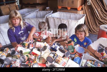 Austin, TX USA: Ragazze e ragazzi di età elementare smistano le merci in scatola durante il programma di volontariato estivo presso la banca del cibo. ©Bob Daemmrich Foto Stock