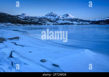 Alba invernale sul lago Bouillouses. Sullo sfondo, picchi Perici (Cerdagne, Pyrénées Orientales, Occitanie, Francia) Foto Stock