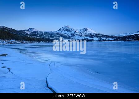 Alba invernale sul lago Bouillouses. Sullo sfondo, picchi Perici (Cerdagne, Pyrénées Orientales, Occitanie, Francia) Foto Stock