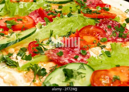 gli ingredienti per lo shawarma sono disposti su un pita sottile: pomodori, verdi, salumi, formaggi, cetrioli e lattuga da vicino Foto Stock