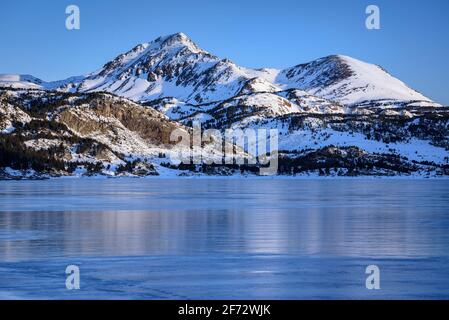 Alba invernale sul lago Bouillouses. Sullo sfondo, picchi Perici (Cerdagne, Pyrénées Orientales, Occitanie, Francia) Foto Stock