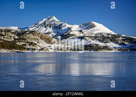 Alba invernale sul lago Bouillouses. Sullo sfondo, picchi Perici (Cerdagne, Pyrénées Orientales, Occitanie, Francia) Foto Stock