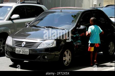 salvador, bahia / brasile - 24 dicembre 2014: Il bambino è visto chiedendo donazioni nel mezzo del traffico di veicoli nel quartiere Pituba di Salvado Foto Stock