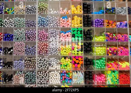 Penne colorate, matite e pennarelli sugli scaffali del negozio. Forniture per ufficio e cancelleria. Penne colorate disposte sullo scaffale. Penne multicolore in un negozio d'arte. Foto Stock