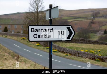 Cartello del Castello di Barnard. Cartello bianco e nero per 10 km, che indica a destra. Arkengarthdale, Yorkshire Dales. REGNO UNITO. Orizzontale. Spazio per la copia. Foto Stock