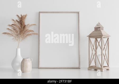 Poster art mockup verticale con struttura in legno, pianta secca in vaso e candelabro in legno su fondo bianco vuoto. Arredamento interno Foto Stock