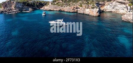 Vista aerea, motoscafo nella baia Cala Llombars, Santanyi, Maiorca, Isole Baleari, Spagna Foto Stock