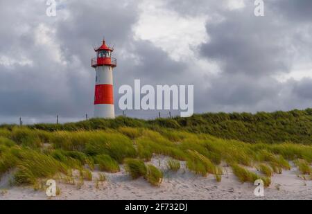 Faro rosso-bianco List-Ost nelle dune di fronte al cielo nuvoloso, Ellenbogen, Sylt, Isola Frisone Nord, Mare del Nord, Frisia settentrionale Foto Stock