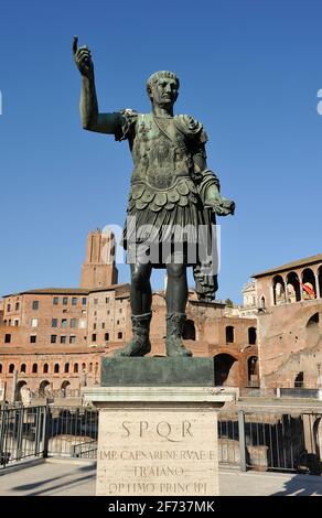 Italia, Roma, statua in bronzo dell'imperatore romano Traiano e mercati di Traiano Foto Stock