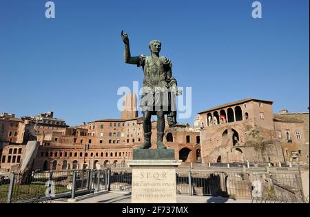 Italia, Roma, statua in bronzo dell'imperatore romano Traiano e mercati di Traiano Foto Stock