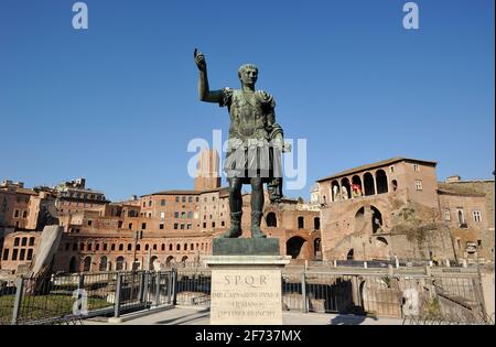 Italia, Roma, statua in bronzo dell'imperatore romano Traiano e mercato di Traiano Foto Stock