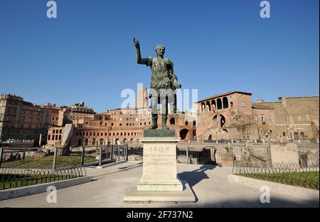 Italia, Roma, statua in bronzo dell'imperatore romano Traiano e mercati di Traiano Foto Stock