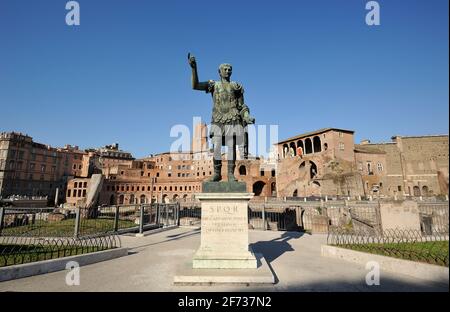 Italia, Roma, statua in bronzo dell'imperatore romano Traiano e mercato di Traiano Foto Stock
