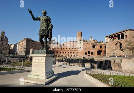 Italia, Roma, statua in bronzo dell'imperatore romano Traiano e mercato di Traiano Foto Stock
