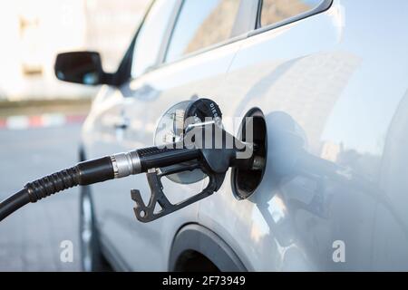 Pompa del gas inserita nel serbatoio della benzina dell'auto, vista ravvicinata, nessuno. Rifornimento di gasolio Foto Stock