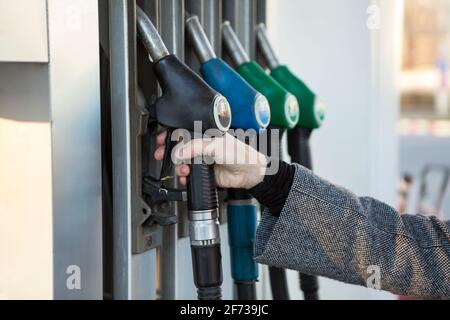 Ugello di rifornimento con guida a mano umana con diesel sulla stazione di servizio, vista ravvicinata Foto Stock