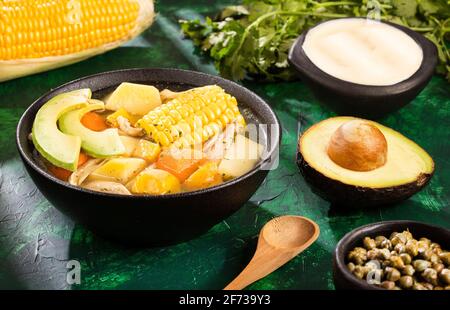 Tradizionale ajiaco colombiano servita su nero piatto di ceramica Foto Stock