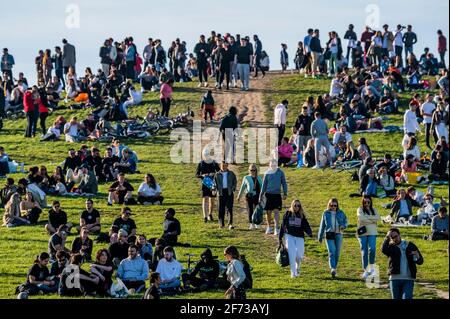 Londra, Regno Unito. 4 Apr 2021. Folle sulla collina di Primrose in una domenica di Pasqua soleggiata sera sotto il blocco e ampiamente seguendo la regola di sei. Credit: Guy Bell/Alamy Live News Foto Stock