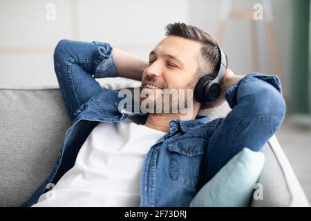 Gioioso uomo di mezza età in cuffia che ascolta la musica Foto Stock